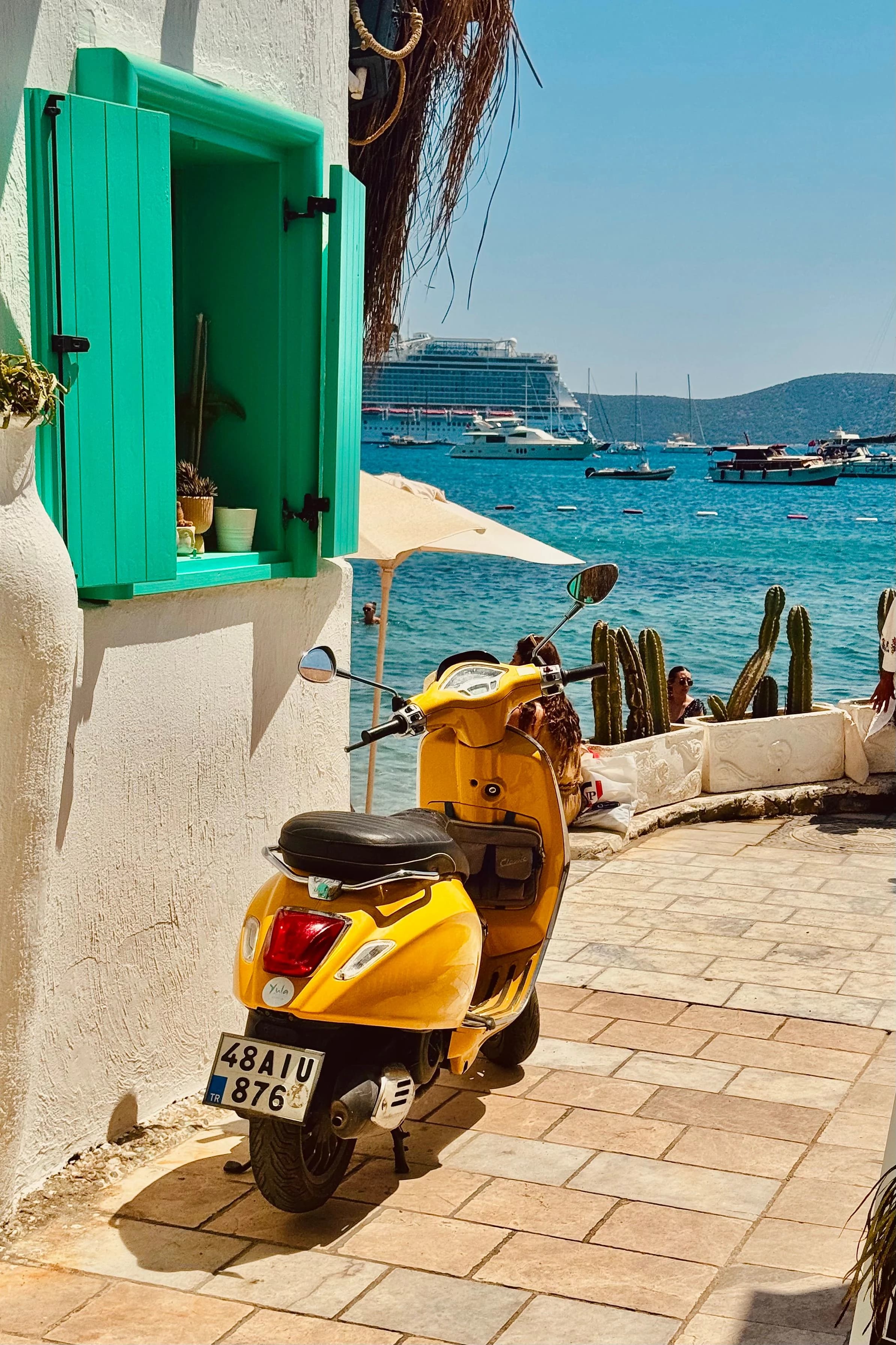 A yellow motor scooter parked near the seaside